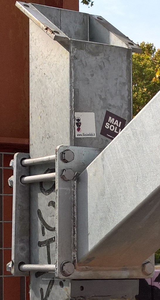 Dettaglio dei morsetti utilizzati per attaccare l'asta che regge il pannello, anziché utilizzare i preesistenti fori presenti all'estremità dell'asta